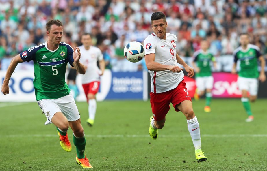 Northern Ireland's Jonny Evans, left, chases Poland's Robert Lewandowski running with the ball during the Euro 2016 Group C soccer match between Poland and Northern Ireland at the Allianz Riviera stadium in Nice, France, Sunday, June 12, 2016. (AP Photo/Thanassis Stavrakis)
