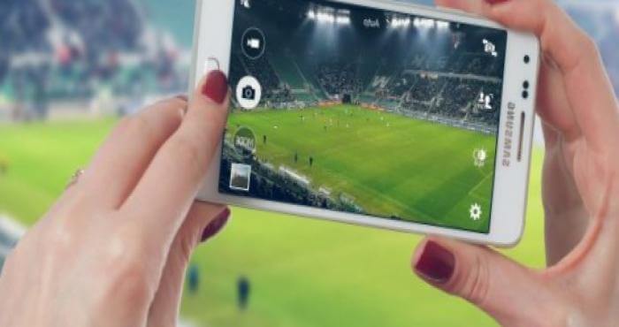 mujer grabando un partido de fútbol con el móvil