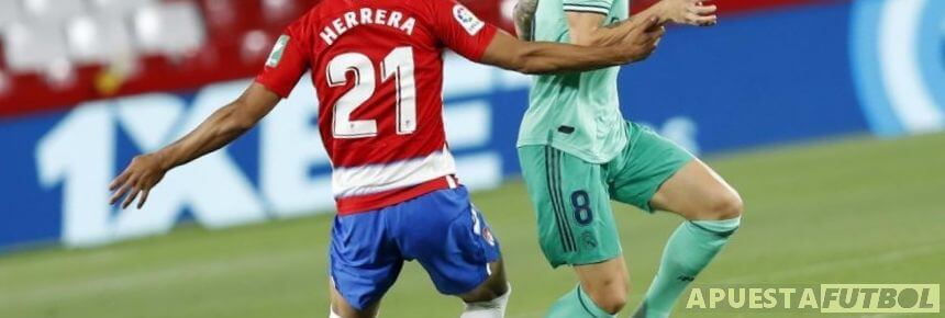 Disputa de balón de jugadores de Real Madrid y Granada en el estadio de Los Cármenes